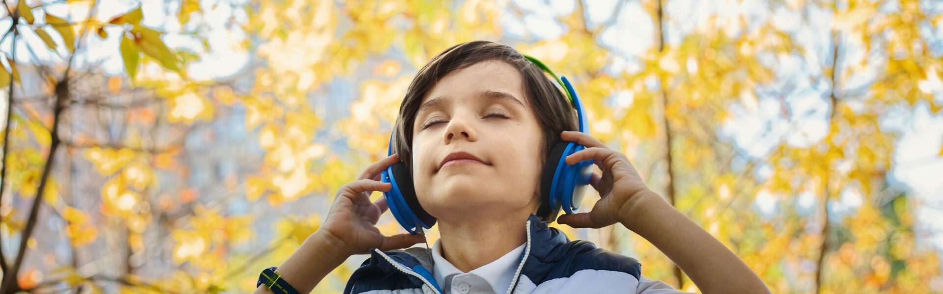 Chłopiec słucha muzyki, ucząc się angielskiego na dworze