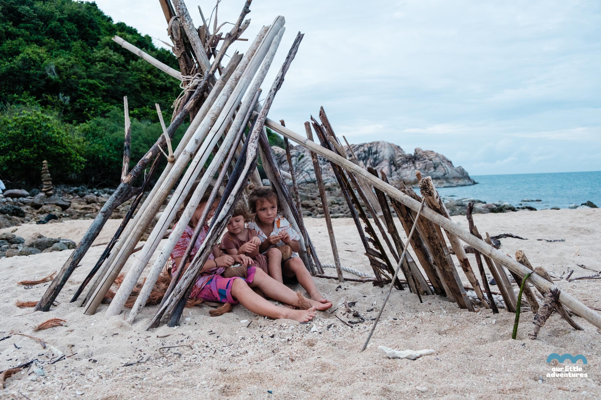 Dzieci siedzące w szałasie na plaży Koh Ma Beach w Tajlandii.