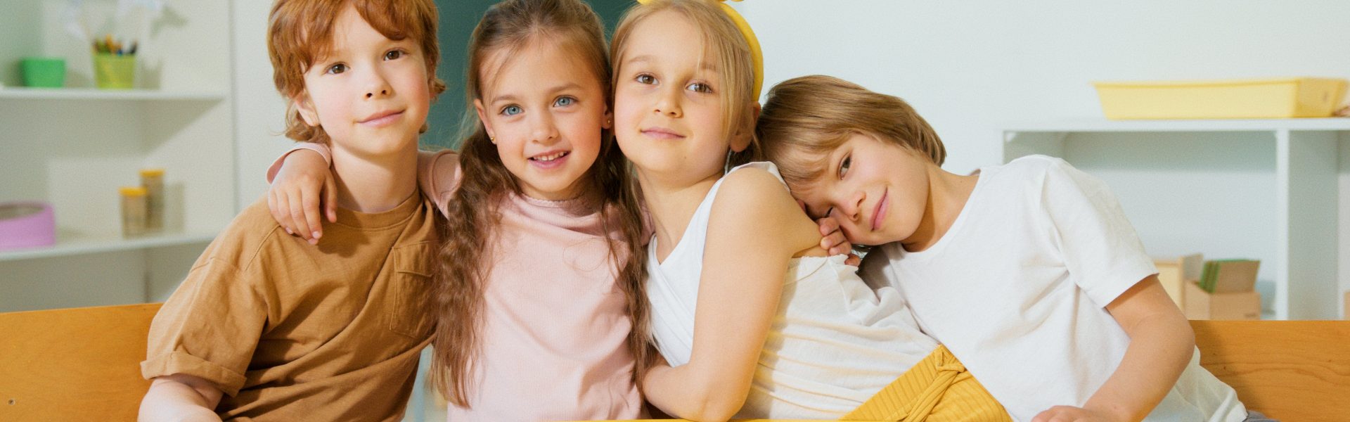 Czworo dzieci siedzi razem na zajęciach przy biurku w szkole.