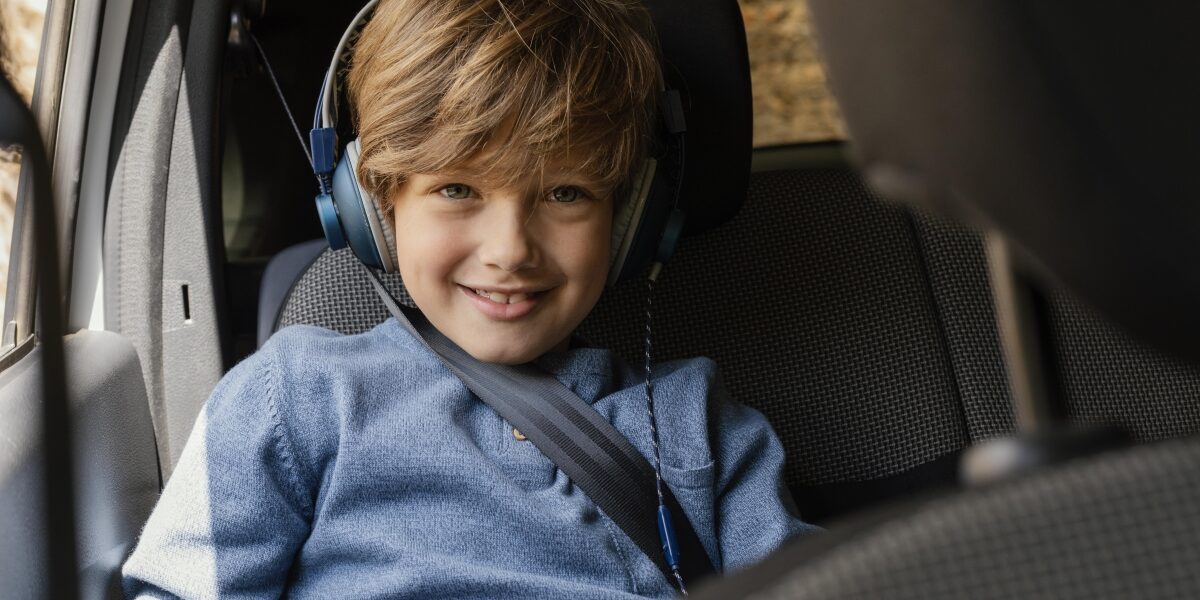 Nauka angielskiego w samochodzie: Chłopiec w aucie ze słuchawkami na uszach.