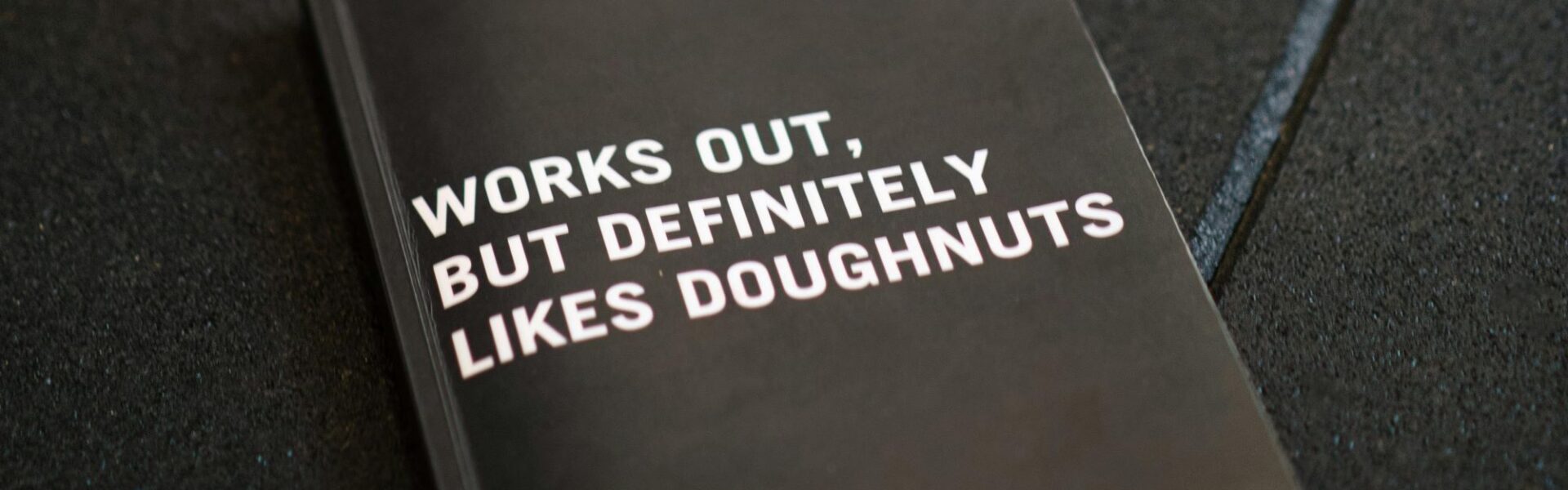 „Works out, but definetely likes doughnuts” - „Ćwiczy, ale zdecydowanie lubi pączki” - „work out” to phrasal verb, którzy może przydać się na każdym etapie nauki angielskiego.