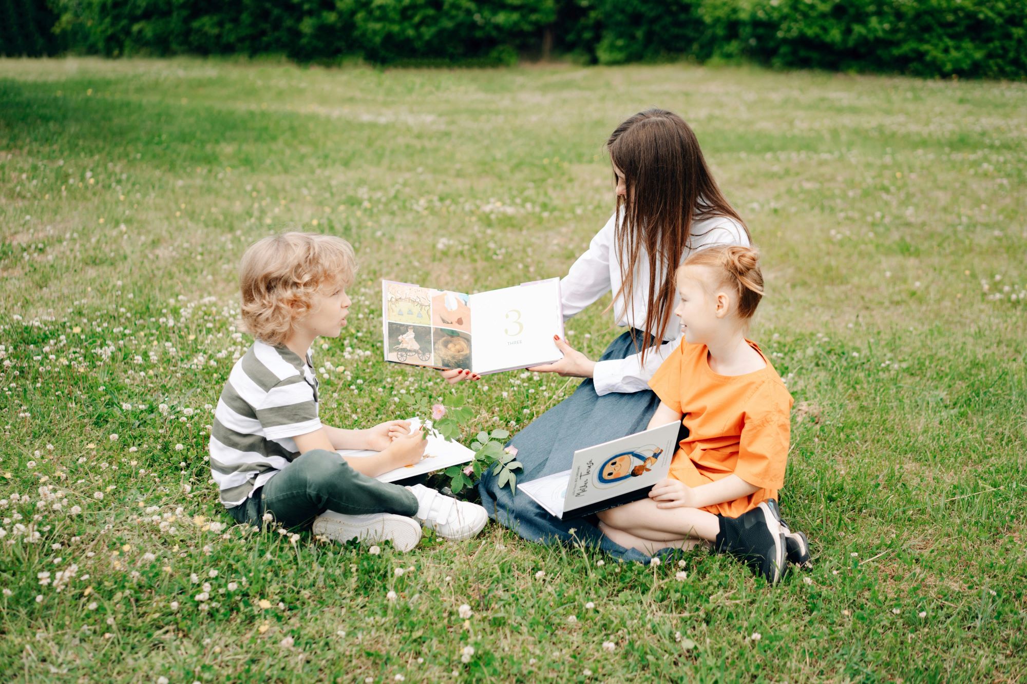 Jak zaplanować wakacje dla dziecka? Wspólne czytanie na trawie.