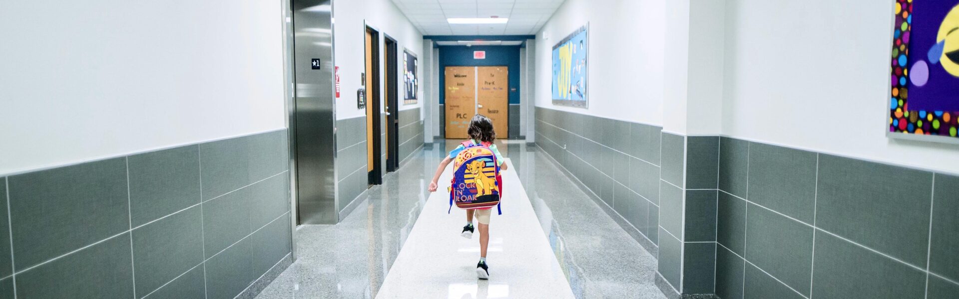 Dziecko w szkole biegnie pustym korytarzem